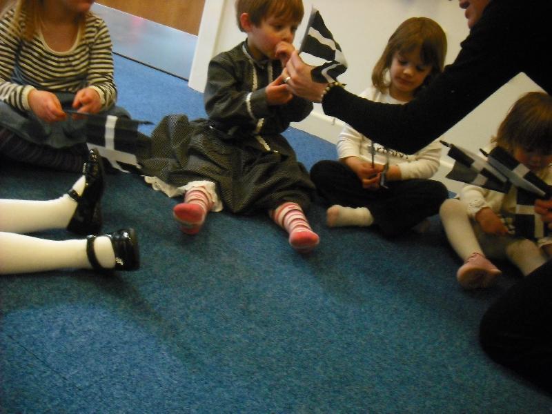 A child at the preschool being given one of the Cornish flags that were donated by the Celtic League (photo: MSM).