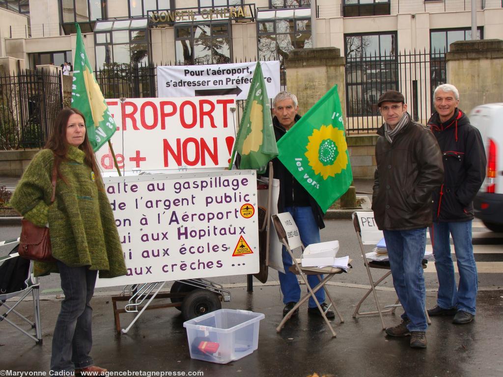<b>13 janvier 2009. Un peu plus de confort pour la Vigie anti-aéroport quotidienne à Nantes : 2-3 chaises et un fauteuil pliants... Et une affiche sur les grilles qui semble dire : <i>C'est pas moi c'est lui...</i></b> !