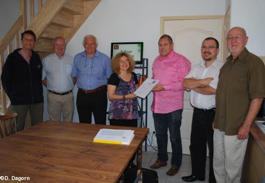 Anne Tignac reçoit la charte des mains de F. Jezequel  de l'agence de développement  aux côtés de Bruno Tignac (deuxième à droite) et de personnalités telles que Claude Guiavarch  maire et conseiller général ou André Lavanant.