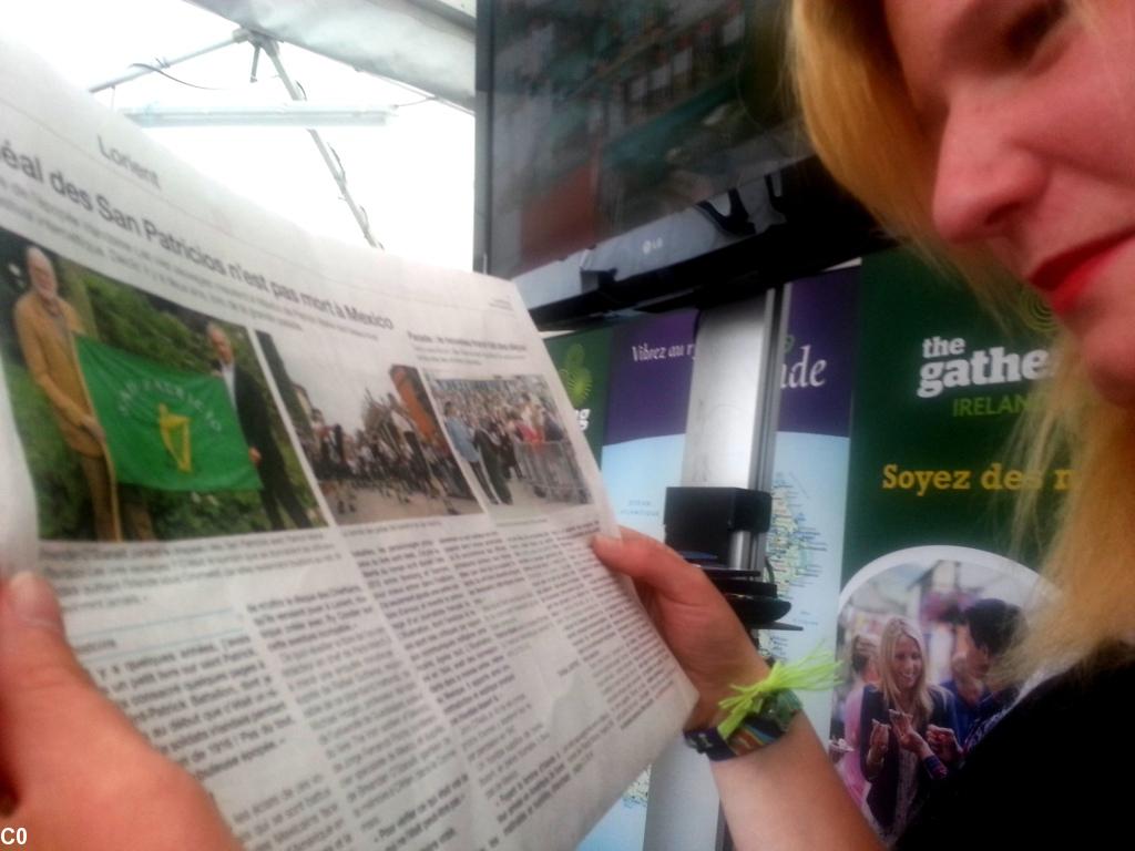 Helena Conway sur le stand de l'Irlande au FIL, lisant la presse du jour sur les oies sauvages