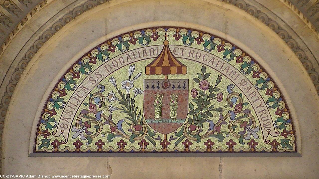Fronton en mosaïque du portail central de la basilique. Donatien et Rogatien y sont représentés. Remarquer les hermines dans le blason. À droite le blason de Nantes, à gauche semis d'hermines.